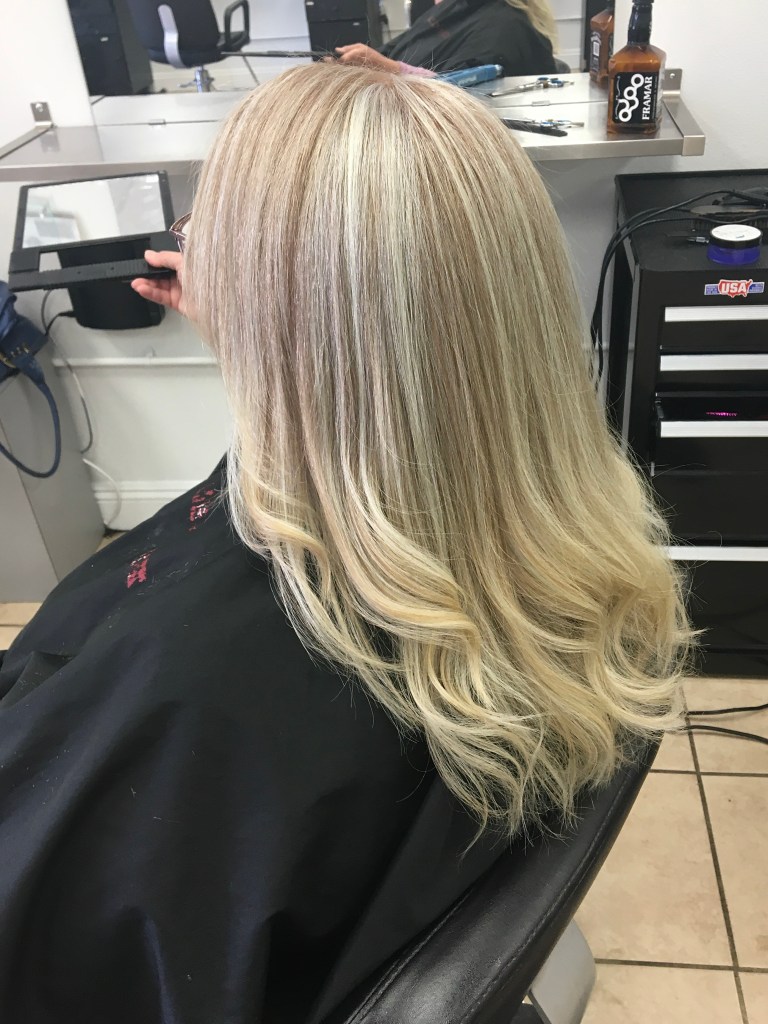 long blonde hair with some waves at the bottom and lighter blonde highlights