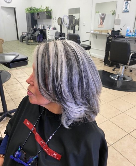 medium length gray haircut with purple and black highlights